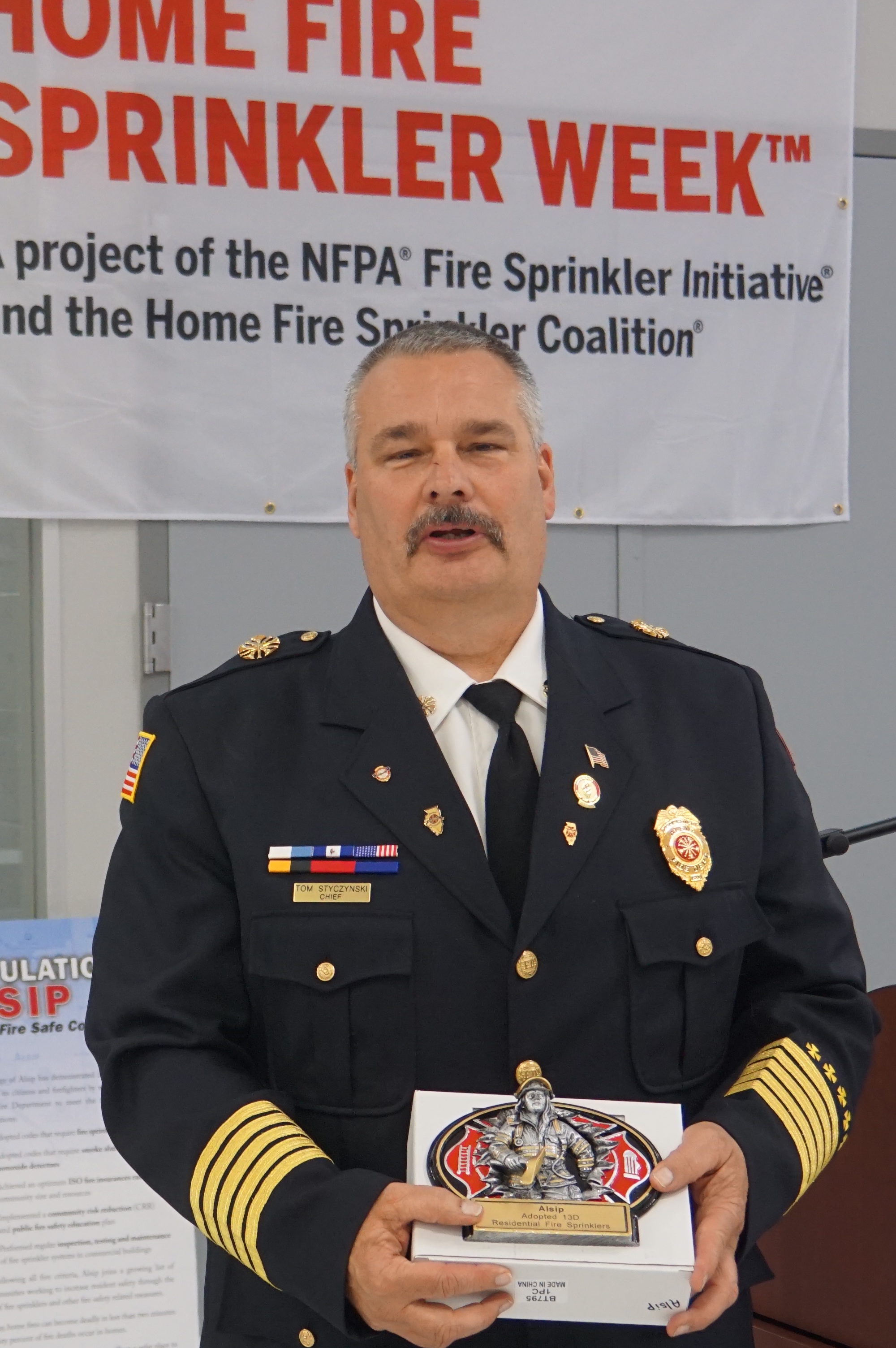 Alsip Fire Chief Tom Styczynski receives the award for being one of NIFSAB’s 111 NFPA 13D Communities.